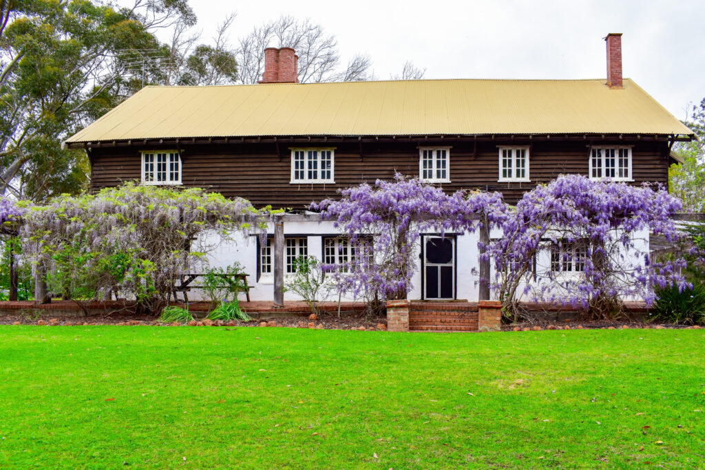 Large accommodation house surrounded by vibrant outdoor plants and green grass at Fairbridge Village