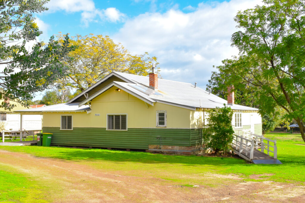 Raleigh Cottage features a delightful house with a white roof and fence, nestled in Fairbridge Village