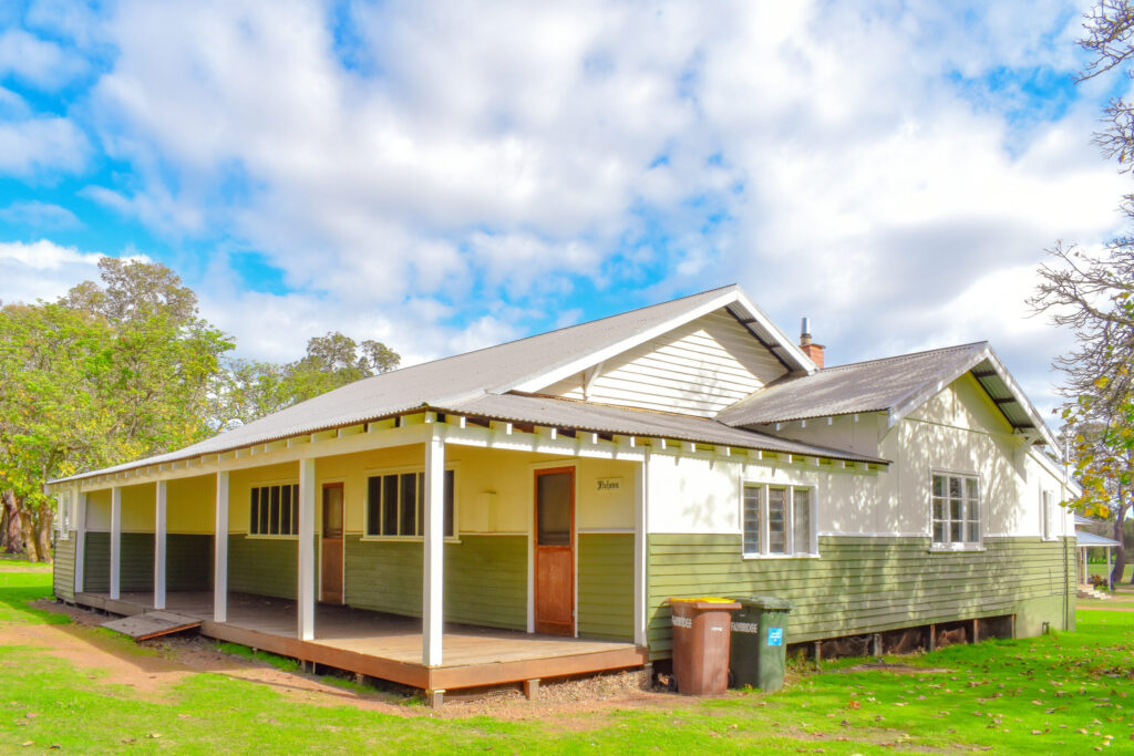 Side view of Nelson Cottage with green and white siding, a south west accommodation at Fairbridge Village