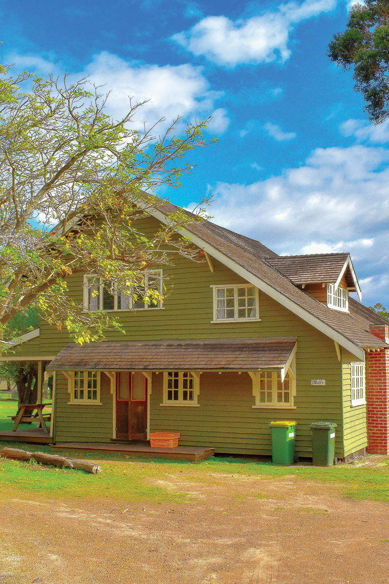 Close-up view of Wolfe Cottage surrounded by trees located in south west accommodation area at Fairbridge Village