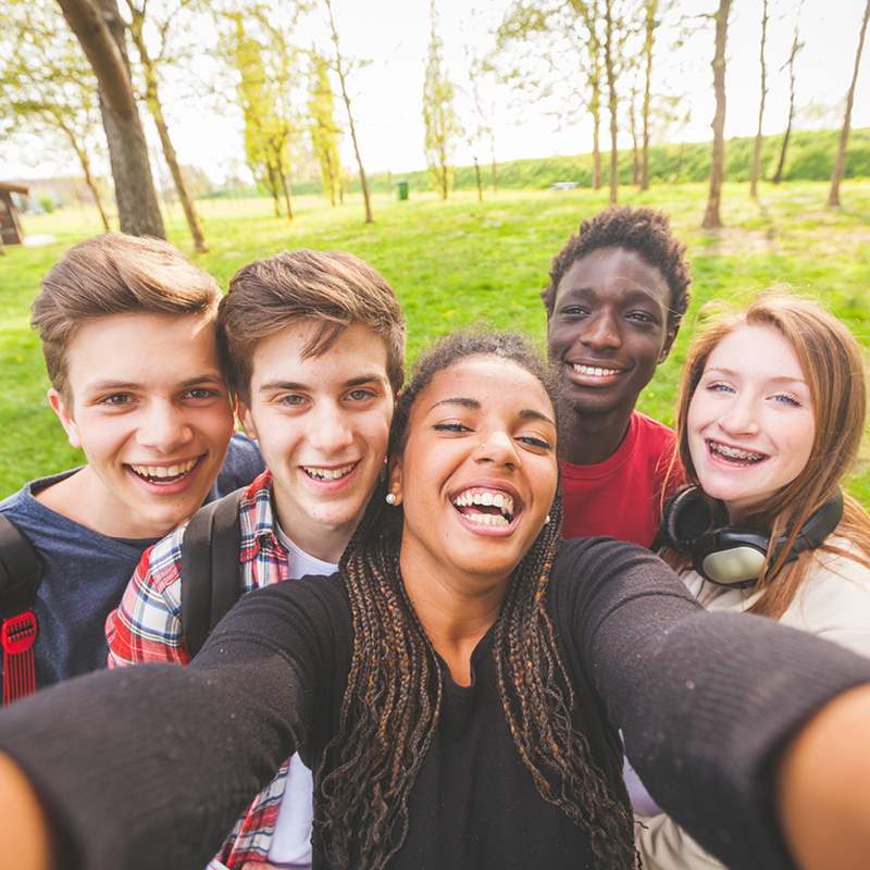 Group of teenagers happily taking a selfie in Fairbridge Village, capturing a moment of joy and friendship