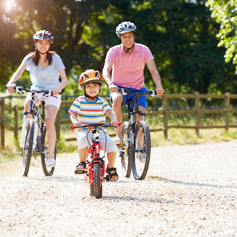 A family of three wearing a helmet during cycling activity at Fairbridge Village