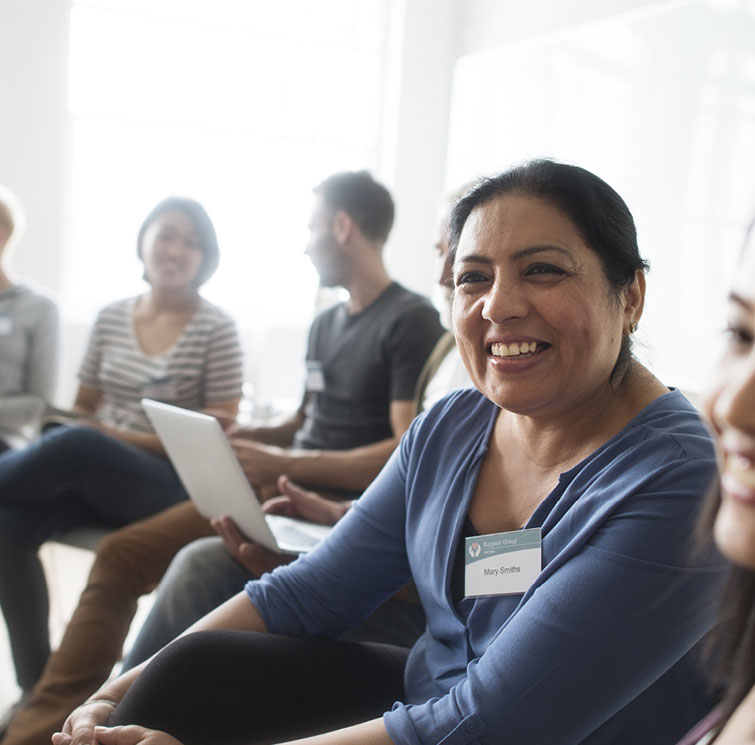 A diverse group of individuals engaged in discussion within a meeting room at Fairbridge Village community