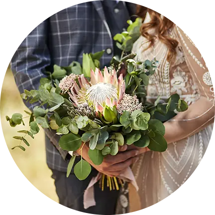 Bride holding a beautiful bouquet with her groom at Fairbridge Village