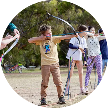 A group of people is practising archery in the designated area at Fairbridge Village