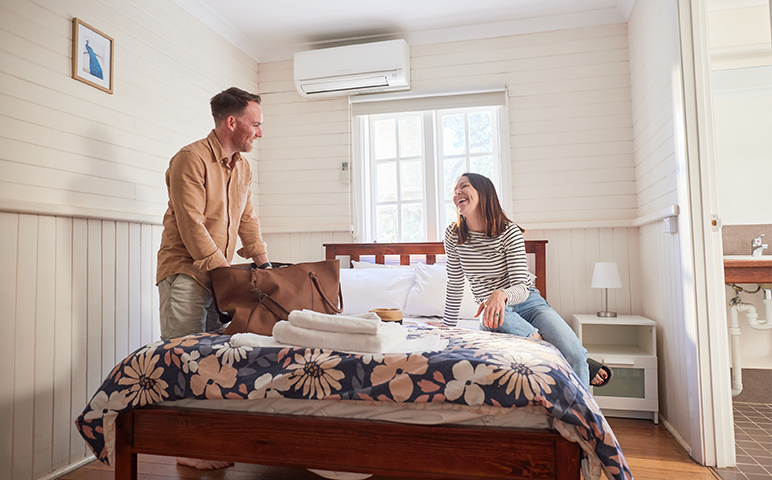 A couple happily talks while unpacking in their cosy room, the best accommodation in Pinjarra
